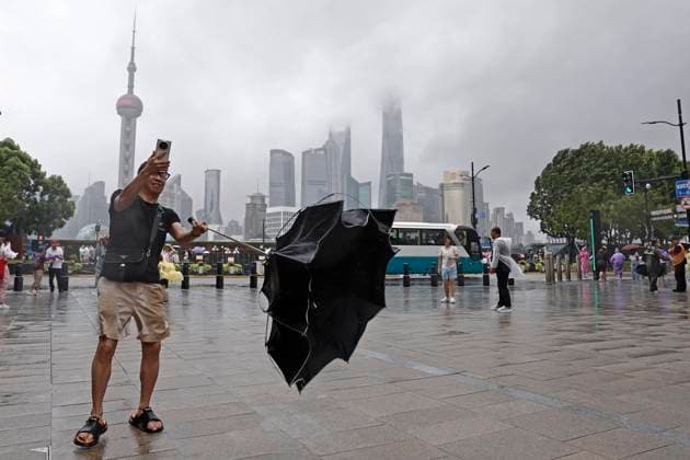 SHANGHAI, CHINA - AUGUST 09: A tourist takes photos with mobile phone while experiencing strong winds on the Bund on August 9, 2026 in Shanghai, China. The Shanghai Meteorological Observatory upgraded the rainstorm warning signal for the central urban area from orange to red at 10:30 a.m. due to the impact of Typhoon Dolphin.  Copyright: xChinaxNewsxServicex 111658975464