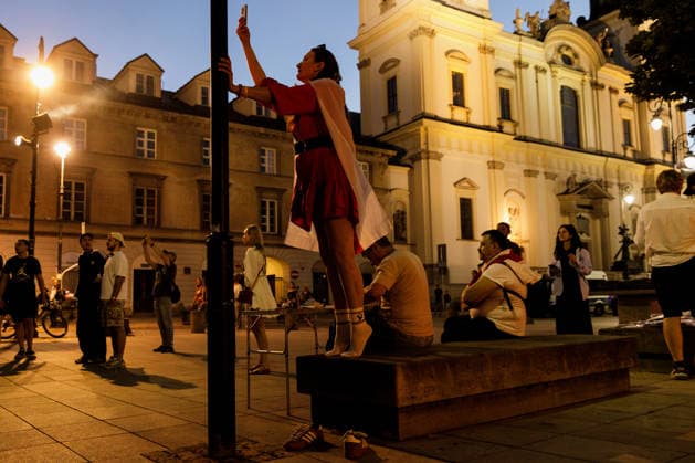 August 9, 2026, Warsaw, Poland: A woman takes off her shoes to climb onto a bench during an evening rally marking the sixth anniversary of the August 2020 presidential election in Belarus. An evening gathering marking the sixth anniversary of the August 2020 presidential election in Belarus was held near the Nicolaus Copernicus Monument in central Warsaw, bringing together leaders of Belarusian democratic forces, public figures and activists, as well as several hundred participants. Warsaw Poland  - ZUMAs197 20260809_aaa_s197_113 Copyright: xVolhaxShukailax