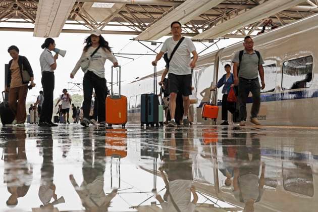 SHANGHAI, CHINA - AUGUST 09: A staff member warns passengers of slippery conditions on the platform at Shanghai Hongqiao Railway Station on August 9, 2026 in Shanghai, China. Yangtze River Delta railways have temporarily suspended services on sections of multiple high-speed lines including Shanghai-Kunming, Hangzhou-Wenzhou and Hangzhou-Taizhou from August 9 to 10 due to Typhoon Dolphin.  Copyright: xChinaxNewsxServicex 111658974847