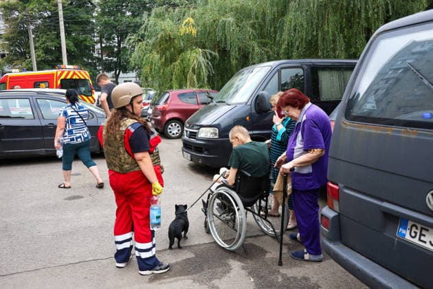 A paramedic stands by residents during a response effort to a Russian S8000 Banderol cruise missile strike on a 10-storey apartment block in the Saltivskyi district, Kharkiv, Ukraine, August 9, 2026. As a result of the terrorist attack, the seventh to tenth floors were destroyed. At present, three people are confirmed dead and 37 others injured. (Photo by Viacheslav Madiievskyi Ukrinform) Russian Banderol missile strikes apartment block in Kharkiv  Copyright: xViacheslavxMadiievskyix
