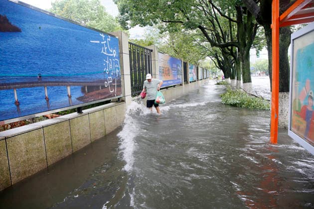 WENLING, CHINA - AUGUST 10: A resident walks through flooded street on August 10, 2026 in Wenling, Zhejiang Province of China. Heavy rainfall brought by Typhoon Dolphin caused severe waterlogging on roads and affecting residents travel. Typhoon Dolphin, the 13th typhoon of the year, made landfall at Yuhuan of Taizhou City, east China s Zhejiang Province, at around 5:30 p.m. on August 9.  Copyright: xVCGx 111659097425