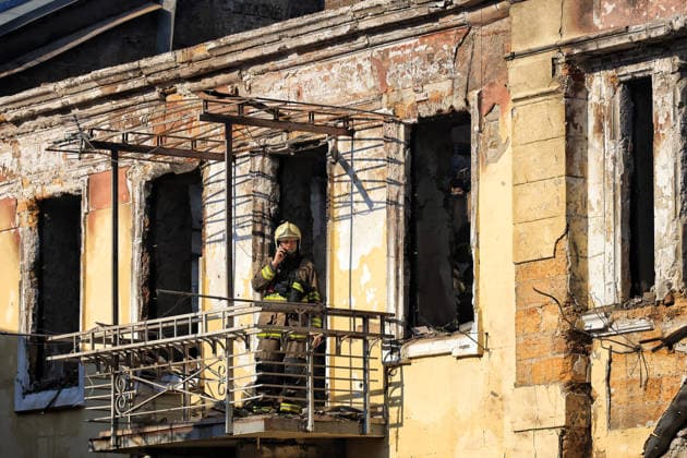 A State Emergency Service worker talks on the phone while standing on the balcony of a multi-storey apartment block in the historical city centre damaged by a Russian attack, Odesa, Ukraine, August 9, 2026. On Sunday night, August 9, the Russian army carried out a massive combined attack on Odesa, causing significant destruction in two districts of the southern Ukrainian port city. In central Odesa, a Russian missile hit a four-storey residential building, where two floors were completely burnt out. Two private houses and offices were also damaged. At least six civilian cars were destroyed or badly damaged in courtyards by falling debris and direct hits. Damage to energy facilities led to a temporary blackout, with partial power outages in  Copyright: xNinaxLiashonokx