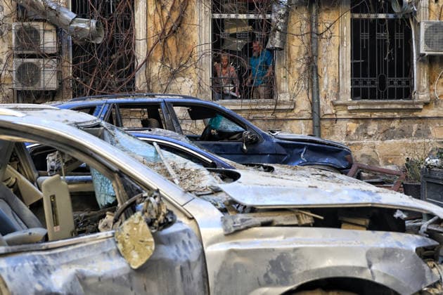 A man and a woman stand in the window as burnt-out cars stay in the courtyard of a multi-storey apartment block in the historical city centre damaged by a Russian attack, Odesa, Ukraine, August 9, 2026. On Sunday night, August 9, the Russian army carried out a massive combined attack on Odesa, causing significant destruction in two districts of the southern Ukrainian port city. In central Odesa, a Russian missile hit a four-storey residential building, where two floors were completely burnt out. Two private houses and offices were also damaged. At least six civilian cars were destroyed or badly damaged in courtyards by falling debris and direct hits. Damage to energy facilities led to a temporary blackout, with partial power outages in the  Copyright: xNinaxLiashonokx