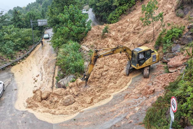 WENZHOU, CHINA - AUGUST 09: Excavators clear landslide debris to reopen a blocked village road on August 9, 2026 in Wenzhou, Zhejiang Province of China. Strong winds up to level 15 (46.2 to 50.9 meters per second) have ripped through Yueqing City in east China s Zhejiang Province since Typhoon Dolphin made landfall in the region on Sunday, with hundreds of toppled trees and broken branches blocking roads across the city.  Copyright: xVCGx 111659124825