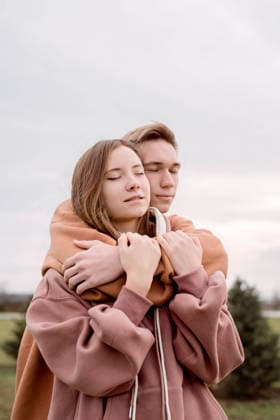 Junges Liebespaar, das sich im Park im Freien umarmt Happy young loving couple wearing hoods embracing each other outdoors in the park (License=RF) ,model released, Symbolfoto Copyright: xZoonar.com IlonaxShorokhovax 25401203 ,model released, Symbolfoto ,property released