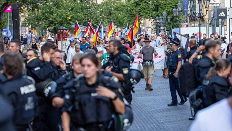 Polizeieinsatz bei Montagsdemo von Team Menschenrechte und Gegenprotesten, Nürnberg, 10.087.2026 Polizeikräfte begleiten einen Demonstrationszug der Team Menschenrechte durch die Karolinenstraße. Teilnehmer tragen Deutschlandfahnen und Transparente, während zahlreiche Einsatzkräfte den Aufzug sichern. Nürnberg Bayern Deutschland *** Police operation during the Monday demonstration by Team Menschenrechte and counter-protests, Nuremberg, 10 087 2026 Police officers escort a demonstration march by Team Menschenrechte through Karolinenstraße. Participants carry German flags and banners, while numerous police officers secure the march. Nuremberg, Bavaria, Germany 20260810-286A4994-M4000