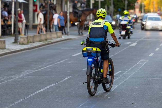 Polizeieinsatz bei Montagsdemo von Team Menschenrechte und Gegenprotesten, Nürnberg, 10.087.2026 Ein Polizeibeamter auf einem Fahrrad begleitet einen Einsatz im Straßenverkehr, im Hintergrund sind berittene Polizei und ein Polizeimotorrad zu erkennen. Nürnberg Bayern Deutschland *** Police operation during the Monday demonstration organized by Team Menschenrechte and counter-protests, Nuremberg, August 10, 2026. A police officer on a bicycle is directing traffic; mounted police and a police motorcycle can be seen in the background. Nuremberg, Bavaria, Germany 20260810-286A5010-M4000