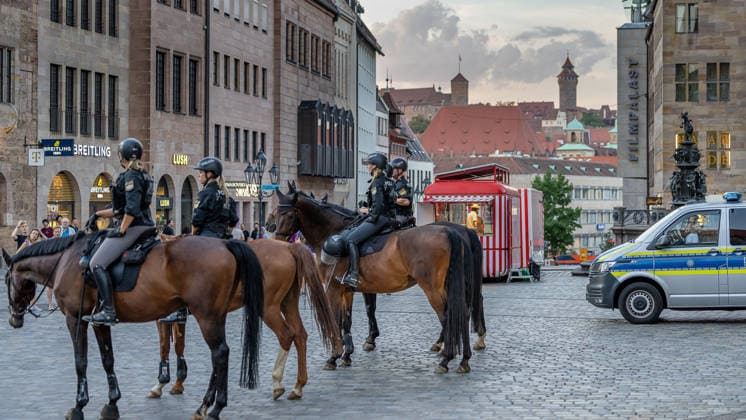 Polizeieinsatz bei Montagsdemo von Team Menschenrechte und Gegenprotesten, Nürnberg, 10.087.2026 Berittene Polizeieinheiten sichern auf dem Lorenzerplatz das Geschehen ab. Im Hintergrund sind die Nürnberger Burg sowie historische Gebäude und ein Einsatzfahrzeug der Polizei zu sehen. Nürnberg Bayern Deutschland *** Police operation during the Monday demonstration by Team Menschenrechte and counter-protests, Nuremberg, 10 087 2026 Mounted police units secure the scene at Lorenzerplatz. In the background are Nuremberg Castle, historic buildings, and a police emergency vehicle. Nuremberg, Bavaria, Germany 20260810-286A5051-M4000