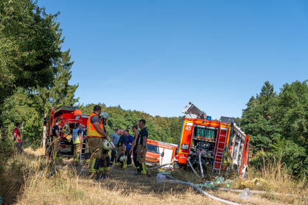 Feuer in Wald und in Wohngebiet fordert weit über 300 Einsatzkräfte Am 10.08.2026 brach gegen 13:15 Uhr zwischen Bad Schwalbach-Adolfseck und Hohenstein-Breithardt ein Waldbrand aus, der sich rasch auf über 8000 Quadratmeter ausbreitete. Rund 300 Feuerwehrkräfte sowie Kräfte von HessenForst bekämpften den Brand, für die Wasserversorgung wurde die B54 gesperrt. Gegen 14:15 Uhr griff parallel in Bad Schwalbach ein Feuer an einem Hang auf einen Anbau mit Garage über. Bei den beiden Einsätzen wurden insgesamt neun Personen leicht verletzt, zwei Einsatzkräfte mussten wegen Rauchgasinhalation ins Krankenhaus gebracht werden. Laut Kreisbrandmeister Michael Ehresmann besteht der Verdacht auf fahrlässige oder vorsätzliche Brandstiftung,