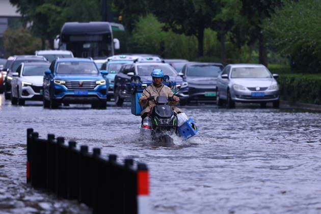 SHANGHAI, CHINA - AUGUST 10: A food delivery rider works on Hongqiao Road near the Inner Ring Elevated Road amid heavy rain and strong winds caused by Typhoon Dolphin on August 10, 2026 in Shanghai, China. The city experienced intense rainfall with some areas reaching extreme levels, leading to waterlogging on multiple road sections.  Copyright: xVCGx 111659181715