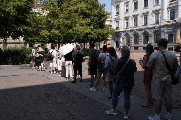 IPA87397533 - Milan, August 11, 2026: It’s hot in Milan. The heat wave continues, and tourists are shielding themselves from the sun with clothing, umbrellas, and hats, and are cooling off or drinking water at the fountain in Piazza Scala.  Copyright: xDuilioxPiaggesix xDuilioxPiaggesix 87397533