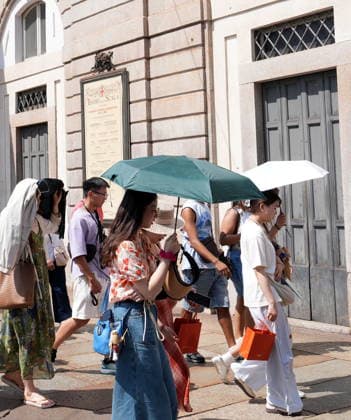 IPA87397526 - Milan, August 11, 2026: It’s hot in Milan. The heat wave continues, and tourists are shielding themselves from the sun with clothing, umbrellas, and hats, and are cooling off or drinking water at the fountain in Piazza Scala.  Copyright: xDuilioxPiaggesix xDuilioxPiaggesix 87397526