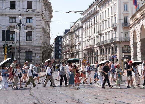 IPA87397530 - Milan, August 11, 2026: It’s hot in Milan. The heat wave continues, and tourists are shielding themselves from the sun with clothing, umbrellas, and hats, and are cooling off or drinking water at the fountain in Piazza Scala.  Copyright: xDuilioxPiaggesix xDuilioxPiaggesix 87397530