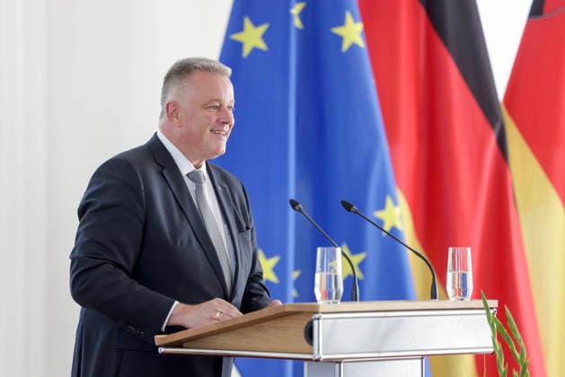 Ministerpräsident Gordon Schnieder am Rednerpult vor Fahnen anlässlich einer Feierstunde zur Verleihung von berufsbezogener Titel in der Staatskanzlei Rheinland-Pfalz 11.08.26 *** Prime Minister Gordon Schnieder at the lectern in front of flags during a ceremony to confer professional titles at the State Chancellery of Rhineland-Palatinate, August 26, 2011