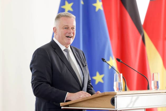 Ministerpräsident Gordon Schnieder am Rednerpult vor Fahnen anlässlich einer Feierstunde zur Verleihung von berufsbezogener Titel in der Staatskanzlei Rheinland-Pfalz 11.08.26 *** Prime Minister Gordon Schnieder at the lectern in front of flags during a ceremony to confer professional titles at the State Chancellery of Rhineland-Palatinate, August 26, 2011