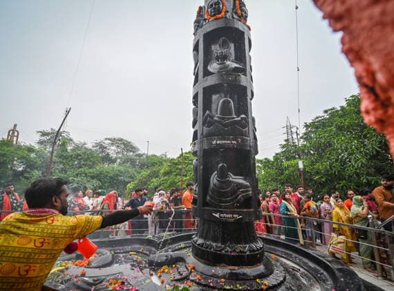 NEW DELHI, INDIA - AUGUST 11: A large number of devotees gather to offer prayers and perform religious rituals on the occasion of Sawan Shivratri at a temple on August 11, 2026 in New Delhi, India. Shravan Shivratri is a sacred Hindu festival dedicated to Lord Shiva, observed on the Krishna Paksha Chaturdashi tithi of the holy month of Shravan. The festival commemorates Lord Shiva consuming the Halahala poison to save the universe during the churning of the cosmic ocean. The devotees bath the shivlinga with Gangajal, raw milk, honey, curd, ghee (Panchamrit) and other cooling liquids to help soothe his intense heat. (Photo by Sanchit Khanna Hindustan Times) Devotees Throng Shiva Temples On Occasion Of Shravan Shivratri Festival