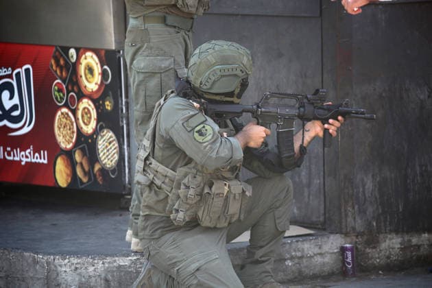Palestinian-Israeli conflict in Nablus - 12 Aug 2026 An Israeli soldier takes position during a raid on Balata refugee camp east of Nablus in the West Bank. Israeli military forces raided the central market during a security operation. Soldiers fired tear gas, causing dozens of Palestinians to suffer from suffocation. Youths threw stones at the soldiers. During the operation, an elderly man was arrested inside the market in Balata refugee camp. Nablus Palestine Copyright: xNasserxishatyehx xSOPAxImagesx Nishtayeh48