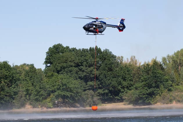 Plauen - Polizeihubschrauber unterstützen Löscharbeiten bei Waldbrand in Plauen Plauen, Meßbach, Messbach, Vogtland, Sachsen, Waldbrand, Vegetationsbrand, Feuerwehr, Löscharbeiten, Polizeihubschrauber, Polizei Sachsen, sächsische Polizei, H145, Airbus H145, Löschhubschrauber, Hubschrauber, Luftunterstützung, Bambi Bucket, Löschwasserbehälter, Außenlast, Wasseraufnahme, Wasserabwurf, Talsperre Pirk, Pirk, Katastrophenschutz, Einsatz, Brandbekämpfung, Glutnester, wildfire, forest fire, firefighting helicopter, aerial firefighting Plauen Sachsen Deutschland *** Plauen Police Helicopters Assist in Firefighting Efforts During a Wildfire in Plauen Plauen, Meßbach, Messbach, Vogtland, Saxony, wildfire, vegetation fire, fire department, Copyright: xEHLxMediax 20260812_plauen-waldbrand-hubschrauber_12
