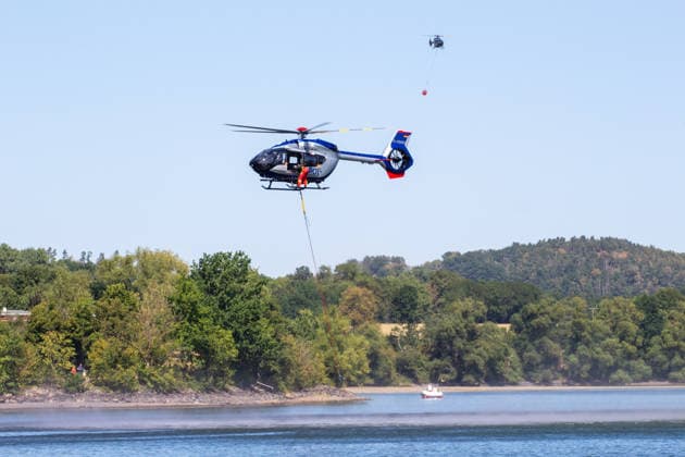 Plauen - Polizeihubschrauber unterstützen Löscharbeiten bei Waldbrand in Plauen Plauen, Meßbach, Messbach, Vogtland, Sachsen, Waldbrand, Vegetationsbrand, Feuerwehr, Löscharbeiten, Polizeihubschrauber, Polizei Sachsen, sächsische Polizei, H145, Airbus H145, Löschhubschrauber, Hubschrauber, Luftunterstützung, Bambi Bucket, Löschwasserbehälter, Außenlast, Wasseraufnahme, Wasserabwurf, Talsperre Pirk, Pirk, Katastrophenschutz, Einsatz, Brandbekämpfung, Glutnester, wildfire, forest fire, firefighting helicopter, aerial firefighting Plauen Sachsen Deutschland *** Plauen Police Helicopters Assist in Firefighting Efforts During a Wildfire in Plauen Plauen, Meßbach, Messbach, Vogtland, Saxony, wildfire, vegetation fire, fire department, Copyright: xEHLxMediax 20260812_plauen-waldbrand-hubschrauber_17