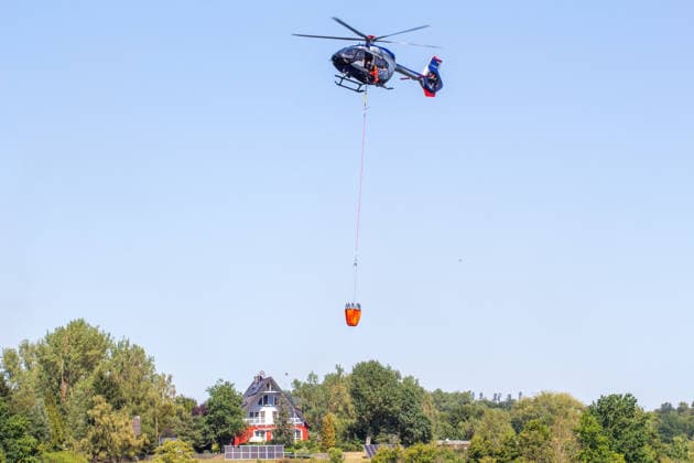 Plauen - Polizeihubschrauber unterstützen Löscharbeiten bei Waldbrand in Plauen Plauen, Meßbach, Messbach, Vogtland, Sachsen, Waldbrand, Vegetationsbrand, Feuerwehr, Löscharbeiten, Polizeihubschrauber, Polizei Sachsen, sächsische Polizei, H145, Airbus H145, Löschhubschrauber, Hubschrauber, Luftunterstützung, Bambi Bucket, Löschwasserbehälter, Außenlast, Wasseraufnahme, Wasserabwurf, Talsperre Pirk, Pirk, Katastrophenschutz, Einsatz, Brandbekämpfung, Glutnester, wildfire, forest fire, firefighting helicopter, aerial firefighting Plauen Sachsen Deutschland *** Plauen Police Helicopters Assist in Firefighting Efforts During a Wildfire in Plauen Plauen, Meßbach, Messbach, Vogtland, Saxony, wildfire, vegetation fire, fire department, Copyright: xEHLxMediax 20260812_plauen-waldbrand-hubschrauber_5