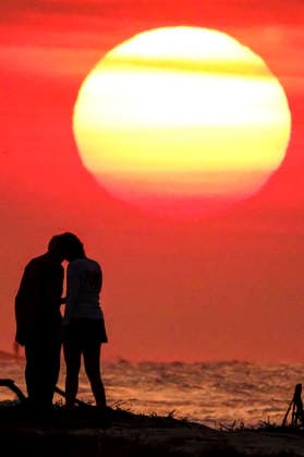 August 12, 2026, Isle Of Palms, Sc, United States: A couple stop for a romantic moment silhouetted by the sunrise, as the massive ball rises over the Atlantic Ocean, August 12, 2026 in Isle of Palms, South Carolina. The Charleston area is currently under a heat advisory with temperatures in the 90Ã¢â‚¬â ¢s and a heat index of 115-degrees. Isle Of Palms United States  - ZUMAe02_ 20260812_zaf_e02_006 Copyright: xRichardxEllisx