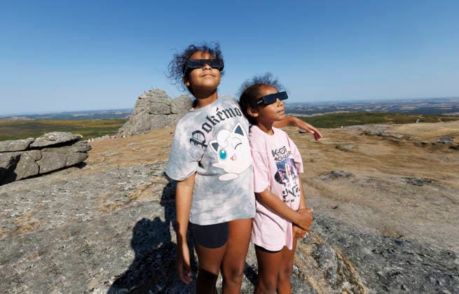 Solar eclipse, Haytor Dartmoor, Devon, UK - 12 Aug 2026 NEWS - Sisters, Nailah and Zahra look towards. the sun with their special solar glasses to watch the eclipse at Haytor Rock ahead of the solar eclipse from Haytor, Dartmoor, Devon where people will come to view the eclipse on 12th August 2026. Haytor Dartmoor Devon GBR Copyright: xPhilxMingo PPAUKx PPA-297128