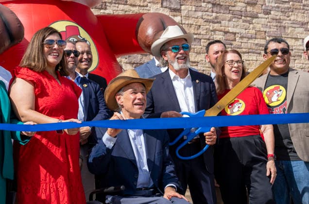 August 12, 2026, San Marcos, Tx, United States: Texas Governor GREG ABBOTT, l, is assisted by found Arch Beaver Aplin during the opening of another 76,000 square foot Buc-ee s convenience store in San Marcos, Texas on August 12, 2026. The store features beaver-themed merchandise, lots of food choices and 124 gas pumps. San Marcos United States - ZUMAd150 20260812_znp_d150_017 Copyright: xBobxDaemmrichx