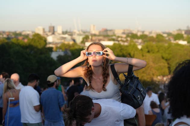 (260812) -- LONDON, Aug. 12, 2026 -- A woman observes the partial solar eclipse on Primrose Hill in London, Britain, Aug. 12, 2026. ) BRITAIN-LONDON-SOLAR ECLIPSE ZhangxFeng 