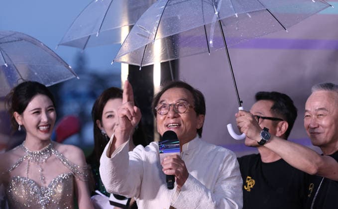 HARBIN, CHINA - AUGUST 12: Jackie Chan walks on the red carpet of the closing ceremony for the 7th Jackie Chan International Action Film Week as director Teddy Chan holds an umbrella for him on August 12, 2026 in Harbin, Heilongjiang Province of China. The event brings together hundreds of filmmakers to celebrate action cinema.  Copyright: xVCGx 111659586562