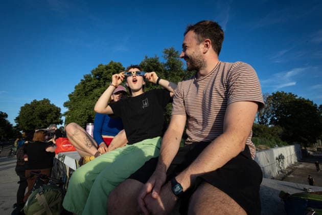 Partial Solar eclipse in Leipzig, Germany - 12 Aug 2026 A person wearing eclipse glasses watches a partial solar eclipse while surrounded by a group of people on a bridge. Residents gathered in the evening to observe the Moon move across the face of the Sun. The eclipse began at 7:17 p.m. CEST and reached its maximum over the city at 8:10 p.m. Leipzig Germany Copyright: xVasilyxKrestyaninovx xSOPAxImagesx _VKR9198
