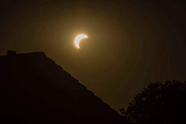 Die Sonne bei einer Sonnenfinsternis über Hausdächern an einem Somemrabend im August, Leutkirch, Baden Württemberg, Deutschland Sonnenfinsternis 20 *** The sun during a solar eclipse above rooftops on a summer evening in August, Leutkirch, Baden-Württemberg, Germany Solar Eclipse 20