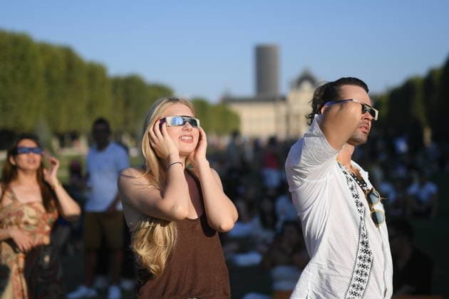 Paris: The public watches the solar eclipse. People on the Champ de Mars watch through solar eclipse viewing glasses as the moon completely passes over the sun s horizon during a partial solar eclipse in Paris on August 12, 2026. 458857 2026 08 12 Paris, France. No people in the frame.  Copyright: xL.Urmanx xStarfacex STAR_458857_008