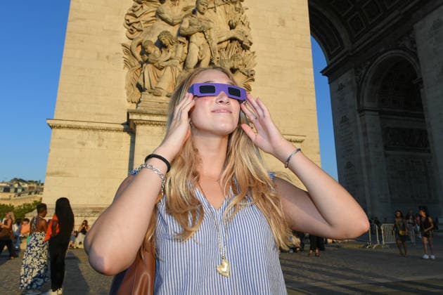 People near the Arc de Triomphe watch through solar eclipse viewing glasses as the moon completely passes over the sun s horizon during a partial solar eclipse in Paris on August 12, 2026. Lionel Urman, Bestimage, Paris, France  Copyright: xLIONELxURMANxx xBESTIMAGExLIONELxURMANxx xBESTIMAGEx