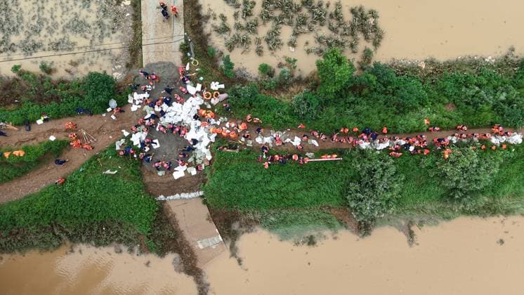(260813) -- PINGDINGSHAN, Aug. 13, 2026 -- An aerial drone photo shows repair work underway at the site of a levee breach along the Beiru River in Jiaxian County, central China s Henan Province, Aug. 13, 2026. Thousands of people have been evacuated in Henan Province after days of torrential rain swelled rivers and triggered a levee breach, local authorities said Thursday. In Pingdingshan City, more than 2,000 people were relocated to safety after a levee along the Beiru River in Jiaxian County gave way on Wednesday night, following extreme rainfall and large-volume discharges from upstream reservoirs. No casualties have been reported so far. ) CHINA-HENAN-PINGDINGSHAN-LEVEE BREACH-REPAIR WORK (CN) YangxJinxin 
