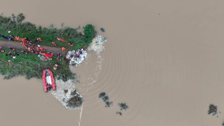 (260813) -- PINGDINGSHAN, Aug. 13, 2026 -- An aerial drone photo shows repair work underway at the site of a levee breach along the Beiru River in Jiaxian County, central China s Henan Province, Aug. 13, 2026. Thousands of people have been evacuated in Henan Province after days of torrential rain swelled rivers and triggered a levee breach, local authorities said Thursday. In Pingdingshan City, more than 2,000 people were relocated to safety after a levee along the Beiru River in Jiaxian County gave way on Wednesday night, following extreme rainfall and large-volume discharges from upstream reservoirs. No casualties have been reported so far. ) CHINA-HENAN-PINGDINGSHAN-LEVEE BREACH-REPAIR WORK (CN) YangxJinxin 