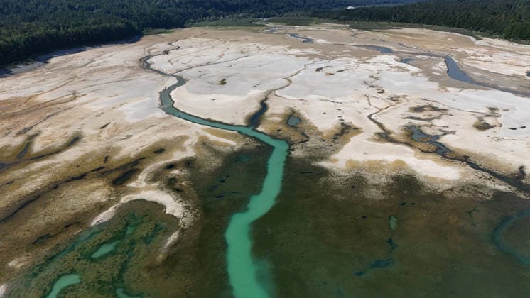 Ein Sommertag am Sylvensteinspeicher, Sylvensteinsee, Sylvensteinstausee bei Fall (Lenggries) (Landkreis Bad Tölz-Wolfratshausen). Hier der Blick auf den Westteil des Sees mit sehr wenig Wasser, kaum Wasser, niedriger Pegel, hitze, Dürre, kein Regen, Klimawandel, Wasserpegel sinkt, Niedrigwasser, ausgetrocknet, trockengelegt, in der Bildmitte bahnt sich die Isar ihren Zufluss *** A summer day at the Sylvenstein Reservoir, Lake Sylvenstein, Sylvenstein Reservoir near Fall Lenggries, Bad Tölz-Wolfratshausen District. Here is a view of the western part of the lake with very little water—barely any water—low water levels, heat, drought, no rain, climate change, water levels dropping, low water, dried up, drained; in the center of the pictur