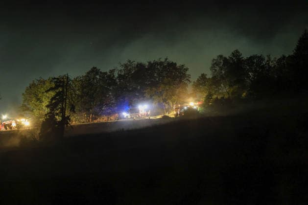 Marsberg, Nordrhein-Westfalen, Deutschland, Europa: Feuerwehrkräfte bekämpfen in der Nacht einen Waldbrand nahe der Diemeltalsperre. Mehrere Löschfahrzeuge und Einsatzkräfte sind entlang des Waldrandes im Einsatz, während Rauch über den Bäumen aufsteigt. Blaulicht, Flutlicht und Einsatzfahrzeuge prägen die nächtliche Szenerie während der laufenden Brandbekämpfung. *** Marsberg, North Rhine-Westphalia, Germany, Europe: Firefighters are battling a forest fire near the Diemel Dam overnight. Several fire trucks and emergency crews are on the scene along the edge of the forest, while smoke rises above the trees. Blue lights, floodlights, and emergency vehicles dominate the nighttime scene as firefighters continue to battle the bla Copyright: xAymanxAlahmedx