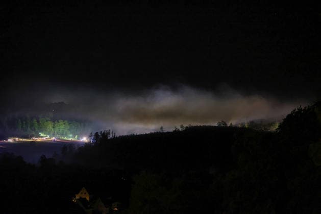 Helminghausen, Marsberg, Nordrhein-Westfalen, Deutschland, Europa: Dichter Rauch zieht während eines nächtlichen Waldbrandeinsatzes nahe der Diemeltalsperre über das Waldgebiet. Im Hintergrund arbeiten Feuerwehrfahrzeuge und Einsatzkräfte entlang der Einsatzstelle, während Scheinwerfer und Blaulicht die Rauchentwicklung und den Waldrand ausleuchten. *** Helminghausen, Marsberg, North Rhine-Westphalia, Germany, Europe: Thick smoke drifts over the forest during a nighttime wildfire operation near the Diemel Dam. In the background, fire trucks and emergency responders are working along the scene of the fire, while spotlights and blue lights illuminate the smoke and the edge of the forest. Copyright: xAymanxAlahmedx
