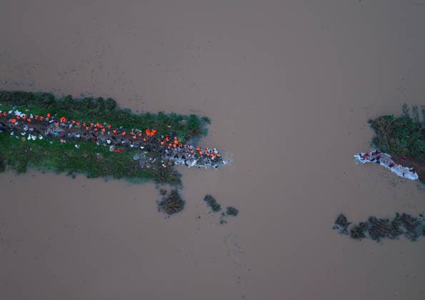 (260814) -- JIAXIAN, Aug. 14, 2026 -- An aerial drone photo shows repair work underway at the site of a levee breach along the Beiru River in Jiaxian County, central China s Henan Province, Aug. 13, 2026. A levee along the Beiru River in Jiaxian County gave way on Wednesday night, following extreme rainfall and large-volume discharges from upstream reservoirs. As of Thursday, a total of 2,182 people had been evacuated to safety, with no casualties reported so far. Efforts to contain the levee breach are underway. ) CHINA-HENAN-JIAXIAN COUNTY-LEVEE BREACH-REPAIR WORK (CN) HaoxYuan 
