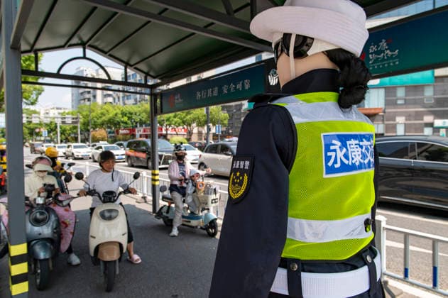 YONGKANG, CHINA - AUGUST 14: A robot traffic police officer advises riders to wear safety helmets at an intersection on August 14, 2026 in Yongkang, Jinhua, Zhejiang Province of China. Local authorities have launched a trial operation of robot traffic police to assist with road safety management.  Copyright: xVCGx 111659918404