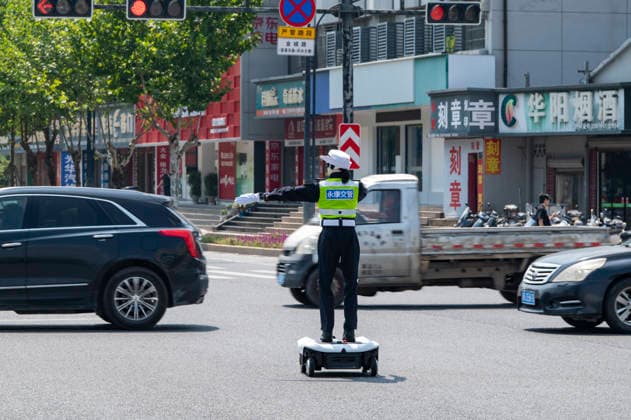 YONGKANG, CHINA - AUGUST 14: A robot traffic police officer assists in directing traffic at an intersection on August 14, 2026 in Yongkang, Jinhua, Zhejiang Province of China. Local authorities have launched a trial operation of robot traffic police to assist with road safety management.  Copyright: xVCGx 111659918429