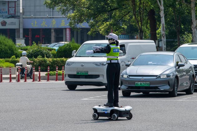 YONGKANG, CHINA - AUGUST 14: A robot traffic police officer assists in directing traffic at an intersection on August 14, 2026 in Yongkang, Jinhua, Zhejiang Province of China. Local authorities have launched a trial operation of robot traffic police to assist with road safety management.  Copyright: xVCGx 111659918430