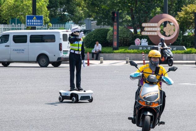 YONGKANG, CHINA - AUGUST 14: A robot traffic police officer assists in directing traffic at an intersection on August 14, 2026 in Yongkang, Jinhua, Zhejiang Province of China. Local authorities have launched a trial operation of robot traffic police to assist with road safety management.  Copyright: xVCGx 111659918419