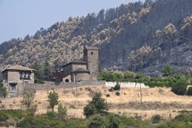 The spread of the fire in Huesca forces the evacuation of belongings from the Monastery of San Juan de la Pena. Forest land burned by a wildfire in the village of La Pena on August 14, 2026, in Las Penas de Riglos, Hoya de Huesca, Huesca, Aragon, Spain. The fire that broke out at 12:37 p.m. this Monday in Las Penas de Riglos, Huesca, has already burned more than 9,000 hectares and forced the preventive evacuation of sixteen villages and a total of 830 people. This Thursday, the flames surrounded the old monastery of San Juan de la Pena, though they did not damage the structure. Early this morning, the regional government issued an evacuation order for four more municipalities, in addition to the twelve from yesterday: these are the towns o  Copyright: xRamonxCometx 7713954