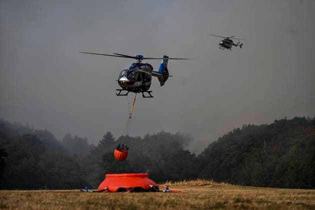 Waldbrände im Kreis Düren in der Eifel Hürtgenwald ** NUR FÜR REDAKTIONELLE ZWECKE ** EDITORIAL USE ONLY **<p>Hubschrauber im Dauereinsatz, beladen ihre Wassertanks in Großhau auf einem Feld , im Hintergrund Rauch vom Waldbrand , am Freitag, dem 14 08 2026 Waldbrände im Kreis Düren in der Eifel Hürtgenwald Deutschland NRW Essen Copyright: KerstinxKokoska *** Forest fires in the Düren district in the Eifel region, Hürtgenwald ** FOR EDITORIAL USE ONLY ** ** EDITORIAL USE ONLY ** Helicopters in continuous operation are filling their water tanks in a field in Großhau, with smoke from the forest fire visible in the background, on Friday, August 14, 2026. Forest fires in the Düren district in the Eifel region, Hürtgenwald, Germa Copyright: KerstinxKokoska doc875prs6qe5k8493cosv ,EDITORIAL USE ONLY