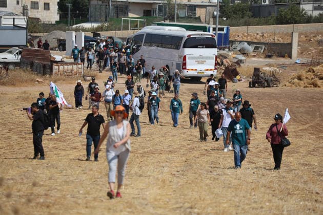 Activists Remove Flags From Beit Sahour Palestinian and Israeli activists walk across open ground toward a Palestinian home in Beit Sahour, east of Bethlehem in the occupied West Bank, on August 14, 2026. The activists said settlers had placed the symbols on the house after October 7, 2023, in what they described as an attempt to seize control of the property, and that settlers opened fire toward them as the items were removed, with no injuries reported. Bethlehem West Bank Palestinian Territories Copyright: xMosabxShawerx