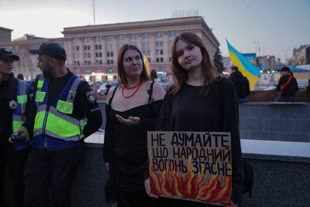 Kharkiv Protesters Demand Reinstatement of Defence Minister Fedorov - Ukraine A woman holds a handmade sign reading in Ukrainian Do not think that the people s fire will go out, flanked by another protester and Dialogue Police officers, at Freedom Square (Ploshcha Svobody) in Kharkiv, Ukraine, on August 14, 2026. Demonstrators gathered to demand the reinstatement of Mykhailo Fedorov as Minister of Defence, part of nationwide protests against his dismissal by President Zelensky; Ukrainian national flags are visible in the background. Photo by Yevhen Titov ABACAPRESS.COM Kharkiv Kharkiv Oblast Ukraine  Copyright: xTitovxYevhen ABACAx