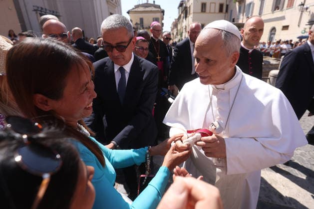 IPA87496256 - Vatican City - Italy, August 15, 2026: An Asian woman presents Pope Leo with a doll depicting the pontiff. Pope Leo XIV presides over Mass for the Solemnity of the Assumption at the papal parish of St. Thomas of Villanova, in the town of Castelli Romani.  Copyright: xmarcoxiacobuccix xmarcoxiacobuccix 87496256