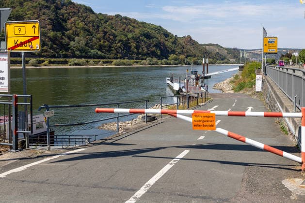 Niedrigwasser am Rhein nach langer Dürrephase, Kaub, 15.08.2026 Eine Schranke sperrt die Zufahrt zur Fährverbindung, ein Hinweisschild informiert über den Ausfall der Fähre wegen Niedrigwassers. Ein Fährschiff liegt am Ufer, der Wasserstand des Flusses ist deutlich abgesenkt. Kaub Rheinland-Pfalz Deutschland *** Low water levels on the Rhine following a long drought, Kaub, August 15, 2026 A barrier blocks access to the ferry crossing; a sign informs passengers that the ferry is out of service due to low water levels. A ferry lies at the riverbank; the river’s water level has dropped significantly. Kaub, Rhineland-Palatinate, Germany 20260815-286A5833-M4000