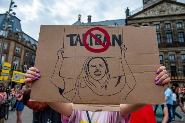 August 15, 2026, Amsterdam, Netherlands: A woman is hiding behind a placard against the Taliban during the rally. On the fifth anniversary of the Taliban™s capture of Kabul, in Afghanistan, several organizations held a demonstration to demand that the Netherlands and the EU stop legitimizing the Taliban and prioritize the rights of Afghan women. Under the Taliban, girls are barred from education beyond primary school, and women are banned from many jobs. There are laws dictating that women must cover their faces in public and forbidding them from entering public parks. Human rights groups call it gender apartheid. Amsterdam Netherlands  - ZUMAs197 20260815_aaa_s197_140 Copyright: xAnaxFernandezx